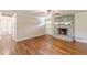 Spacious living room boasts a stone fireplace, hardwood floors, front door, and ceiling fan at 7928 S Giles Rd, Douglasville, GA 30135