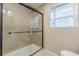 Bathroom featuring a tiled shower with sliding glass doors and a window at 7928 S Giles Rd, Douglasville, GA 30135
