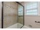 Shower with tiled walls, sliding glass door, and natural light from nearby window at 7928 S Giles Rd, Douglasville, GA 30135