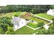 Aerial view featuring a house with a green yard surrounded by a white fence and mature trees at 1087 Yellow River Dr, Lawrenceville, GA 30043