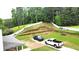 Spacious backyard with long gravel driveway, partial brick patio and sloped yard at 1087 Yellow River Dr, Lawrenceville, GA 30043