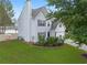 Exterior view of home with lush green lawn, mature trees, and gray siding plus updated landscaping at 1087 Yellow River Dr, Lawrenceville, GA 30043