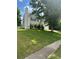 View of the house on a grassy lot with a two-car garage, windows with dark shutters, and a sidewalk on the side at 1087 Yellow River Dr, Lawrenceville, GA 30043