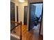 Hallway featuring hardwood floors with access to three rooms and a staircase with white railing at 1087 Yellow River Dr, Lawrenceville, GA 30043