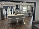 Modern kitchen with central island, bar stools, and stainless steel appliances. Accented with dark-toned hardware and light fixtures at 1087 Yellow River Dr, Lawrenceville, GA 30043