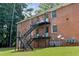 Rear exterior with black metal stairs, doors, and gas meters on green lawn at 135 E Hill St # 22, Decatur, GA 30030