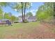 View of the spacious backyard with lush green grass, playset, and mature trees at 403 Rustic Ridge Cir, Lawrenceville, GA 30043