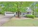 Charming home featuring a well-manicured front yard with mature trees and a welcoming front porch at 403 Rustic Ridge Cir, Lawrenceville, GA 30043
