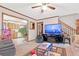 Cozy living room featuring wood trim, neutral walls, ceiling fan, and access to the kitchen and stairs at 403 Rustic Ridge Cir, Lawrenceville, GA 30043