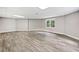 Unfinished basement with wood-look flooring, natural light, and ample space at 515 Old Chartwell Xing, Alpharetta, GA 30022