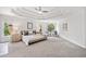 A luxurious bedroom with a tray ceiling, large arched window, and neutral decor at 515 Old Chartwell Xing, Alpharetta, GA 30022