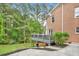 Exterior view of a home featuring a deck, lush landscaping, and a well-maintained driveway and yard at 515 Old Chartwell Xing, Alpharetta, GA 30022