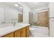 Bright bathroom with tile shower, wood vanity, white counters and large mirror at 890 Lake Dr, Snellville, GA 30039
