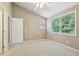 This bedroom boasts neutral walls, carpet, a ceiling fan, and natural light at 890 Lake Dr, Snellville, GA 30039