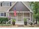Inviting front porch with decorative plants, an American flag, and the house number prominently displayed at 890 Lake Dr, Snellville, GA 30039