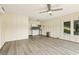 Bright living room featuring wood-look floors, a ceiling fan, and a kitchenette with modern white cabinets at 890 Lake Dr, Snellville, GA 30039