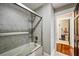 Bathroom featuring a shower-tub combo with glass doors and tiled walls at 1371 N Highland Ne Ave, Atlanta, GA 30306