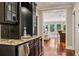 Butler's pantry with granite countertops and dark cabinets, seamlessly connecting living spaces at 1371 N Highland Ne Ave, Atlanta, GA 30306