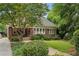 Charming brick home with a covered front porch, landscaped yard, and mature trees at 1371 N Highland Ne Ave, Atlanta, GA 30306