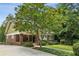 Charming brick home with a covered front porch, landscaped yard, and mature trees at 1371 N Highland Ne Ave, Atlanta, GA 30306