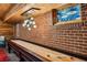 Basement game room features a shuffleboard table, exposed brick wall, and decorative glass window at 1371 N Highland Ne Ave, Atlanta, GA 30306