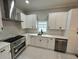 Well-lit white kitchen featuring stainless steel appliances and modern cabinetry at 1766 W Lyle W Ave, College Park, GA 30337