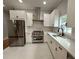 White kitchen boasts stainless steel appliances, sleek cabinetry, and elegant countertops at 1766 W Lyle W Ave, College Park, GA 30337