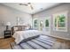 Bright main bedroom features a ceiling fan, light gray walls, light wood floors, and a door to the porch at 754 Fayetteville Se Rd, Atlanta, GA 30316