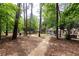 Lush backyard with mature trees and a pathway leading to outdoor seating, creating a serene escape at 1443 Fama Ne Dr, Atlanta, GA 30329