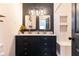 Bathroom featuring a double vanity with black cabinets, white countertops, and a tiled shower at 1443 Fama Ne Dr, Atlanta, GA 30329