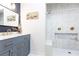 Bathroom featuring a marble vanity with gold fixtures and a tiled shower with a built-in bench at 1443 Fama Ne Dr, Atlanta, GA 30329
