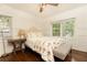 Cozy bedroom with hardwood floors, a ceiling fan, a side table and a large window at 1443 Fama Ne Dr, Atlanta, GA 30329