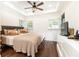 Bright bedroom with a ceiling fan, tray ceiling, large window, and hardwood floors at 1443 Fama Ne Dr, Atlanta, GA 30329