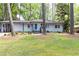Charming single-story home with a well-manicured lawn, mature trees, and a welcoming blue front door at 1443 Fama Ne Dr, Atlanta, GA 30329