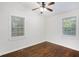 Bedroom features wood floor, a ceiling fan, and two windows for natural light at 1636 Mary George Nw Ave, Atlanta, GA 30318