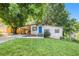 Charming home featuring a bright blue front door, carport, landscaped yard, and mature trees at 1636 Mary George Nw Ave, Atlanta, GA 30318