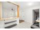 Bright kitchen with light tile flooring, modern shelving, and a breakfast bar that opens to an airy living area at 1636 Mary George Nw Ave, Atlanta, GA 30318