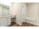 Bathroom featuring granite countertops, wood-look floors, and a separate soaking tub at 225 Limestone Cir, Conyers, GA 30013