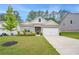 Cozy home with neat landscaping, a two-car garage, and classic gray siding under a clear sky at 225 Limestone Cir, Conyers, GA 30013