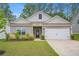 Charming single-story home featuring a two-car garage, manicured lawn, and welcoming gray siding at 225 Limestone Cir, Conyers, GA 30013