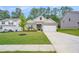 Inviting gray home with a well-maintained lawn, complemented by lush greenery and a paved driveway at 225 Limestone Cir, Conyers, GA 30013
