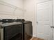 Laundry room with a shelf, black appliances, and wood-look floors at 225 Limestone Cir, Conyers, GA 30013