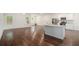 Open-concept living room and kitchen with wood floors, white walls and plenty of natural light at 225 Limestone Cir, Conyers, GA 30013