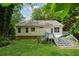 Back of home showcasing a deck with stairs and a well-maintained grassy lawn at 540 Alcovy Hills Dr, Lawrenceville, GA 30045