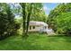 Secluded backyard features a well-maintained lawn, mature trees, and a deck, offering serene outdoor living at 540 Alcovy Hills Dr, Lawrenceville, GA 30045