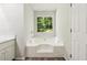 Bright white soaking tub with a view of the yard at 540 Alcovy Hills Dr, Lawrenceville, GA 30045