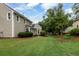 Backyard with green grass, mature trees, and landscaping at 303 Roswell Green Ln, Roswell, GA 30075