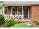 Inviting front porch with seating and a brick facade provides a cozy welcome at 303 Roswell Green Ln, Roswell, GA 30075
