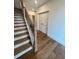 View of hardwood stairs with white risers, dark railing, and light walls at 435 Chiswick Cir # 21, Alpharetta, GA 30009