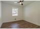 Cozy bedroom with wood-look floors, a ceiling fan, and a large window, offering a comfortable retreat at 5207 Dixie Lake Rd, Union City, GA 30291